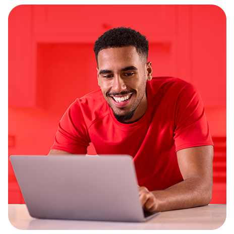Homem sorridente usando notebook para negociar sua dívida Besni de forma online.