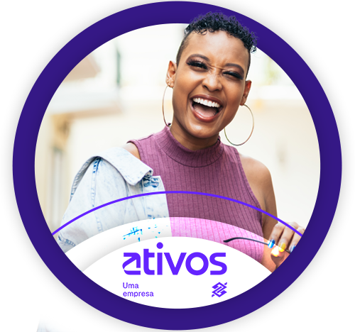 Mulher negra sorridente com brinco de argola grande, usando blusa sem mangas roxa e jaqueta jeans apoiada no ombro, segurando um óculos na mão. Ela está em destaque dentro de um círculo roxo com a marca "ativos" na parte inferior, acompanhada do texto "Uma empresa" e do logotipo da Ativos. O fundo é claro e desfocado, transmitindo leveza e descontração.