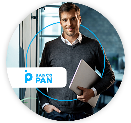 Homem de pé segurando um notebook, ao lado do logo do Banco PAN.