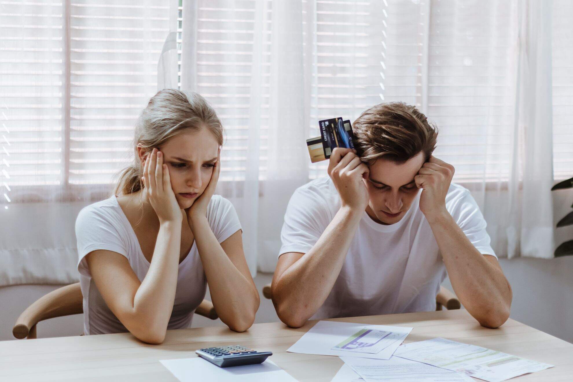 Homem e mulher fazendo as contas e com dívidas